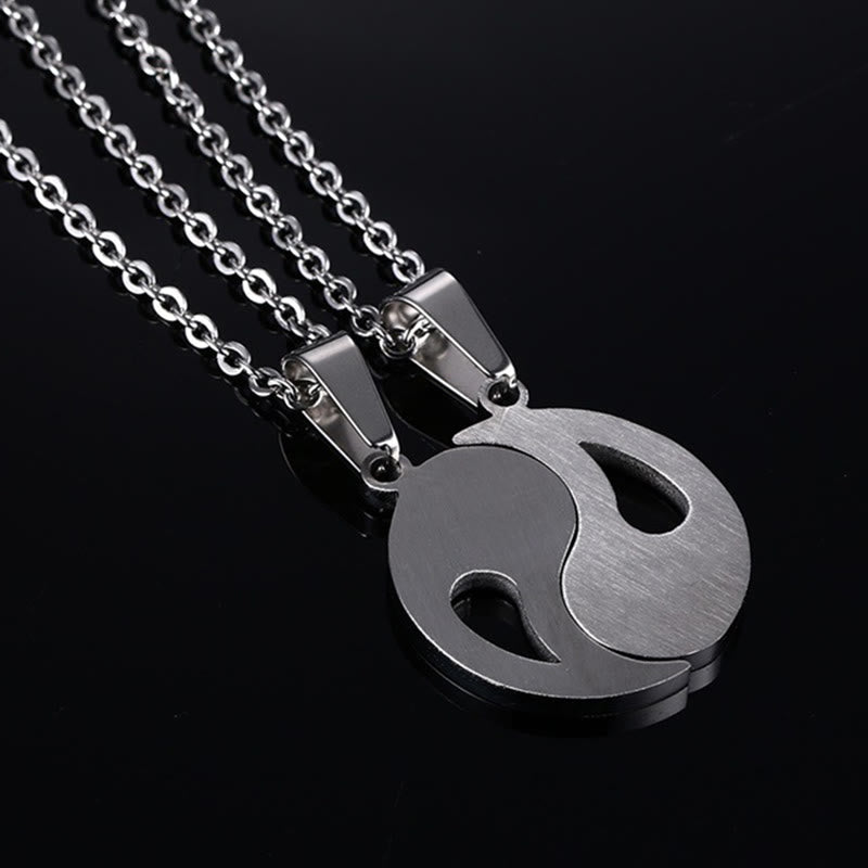 Yin Yang Pendant Couple Necklace Set - Two silver-tone yin-yang pendant halves on dark background, matching friendship nec...