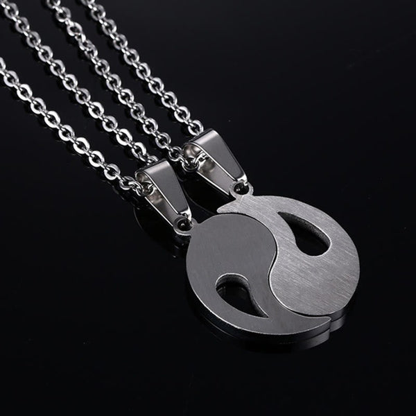 Yin Yang Pendant Couple Necklace Set - Two silver-tone yin-yang pendant halves on dark background, matching friendship nec...