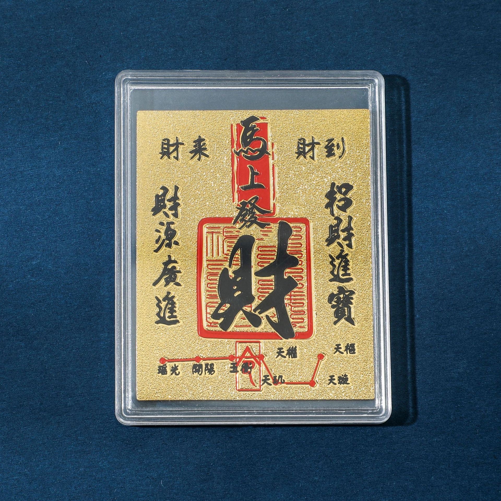 Gold Instant Wealth fortune sticker in clear display case on blue background