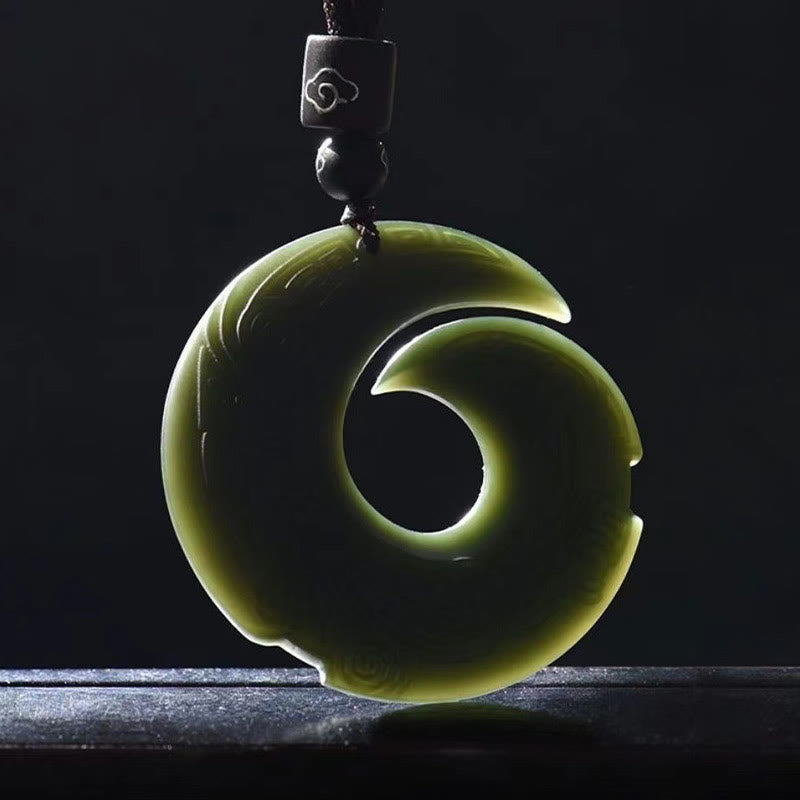 Hetian Cyan Jade Peace Buckle Luck Necklace – Backlit dark olive-green jade pendant showing translucent spiral S-curve form with polished finish