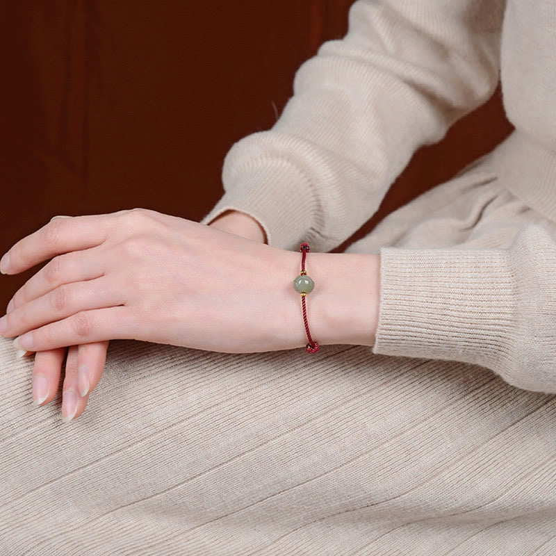 Hetian Jade Lotus Red String Bracelet - Worn on model wrist with knit top, 45-degree view, adjustable charm