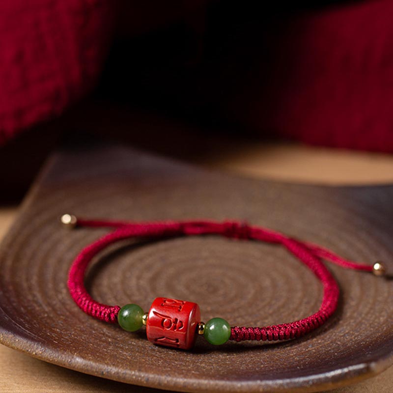 Tibetan Cinnabar Braided Rope Bracelet – On dark ceramic plate, full bead arrangement with gold spacers