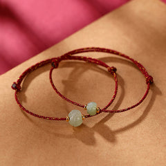 Hetian Jade Lotus Red String Bracelet - Paired lotus-carved beads on red cord with gold thread, flat lay, lucky charm