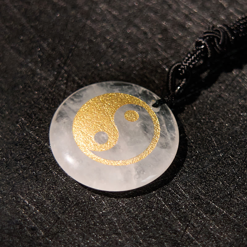 Yin Yang Crystal Necklace – White quartz crystal pendant with gold glitter yin-yang symbol, polished translucent stone on bla