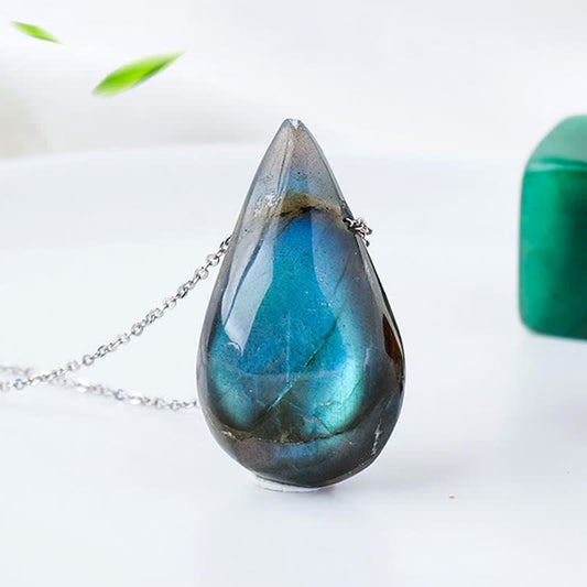 Labradorite water drop pendant necklace with striking blue-green iridescent labradorite teardrop cabochon on delicate silver chain displaying natural color flash against soft green botanical background
