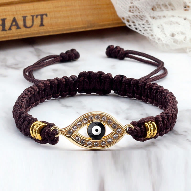 Burgundy cord evil eye bracelet with gold crystal pave charm on white marble