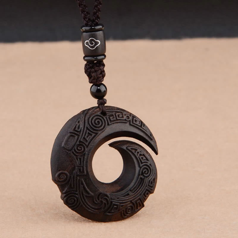 Red sandalwood peace buckle spiral pendant necklace with carved cloud scroll and geometric key patterns on dark hardwood disc with black spherical bead and silver cloud-inlaid cylinder spacer