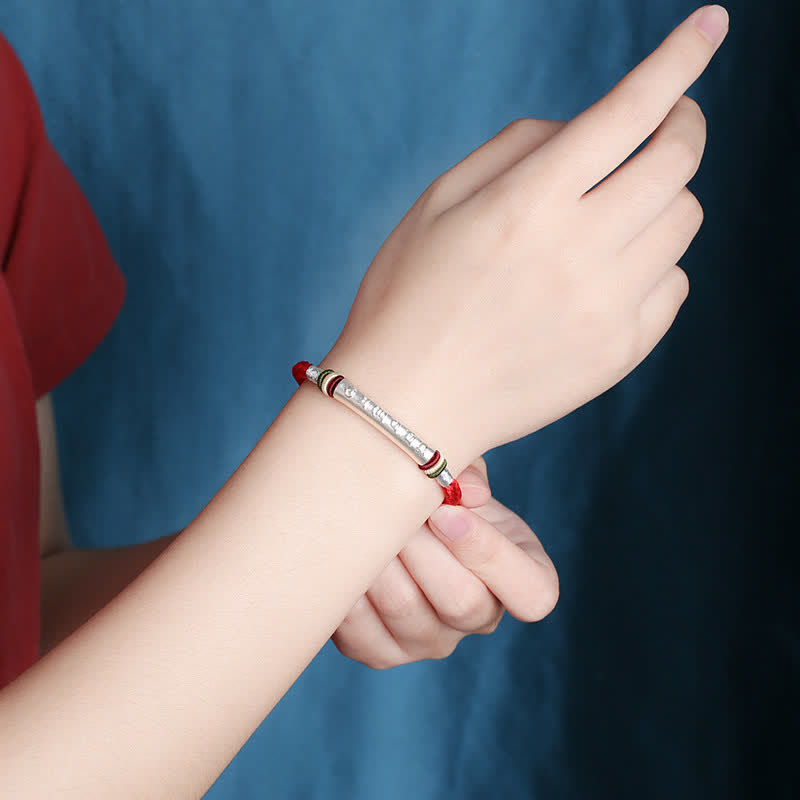 Om Mani Padme Hum Red String Bracelet – Red cord with silver mantra cylinder worn on wrist