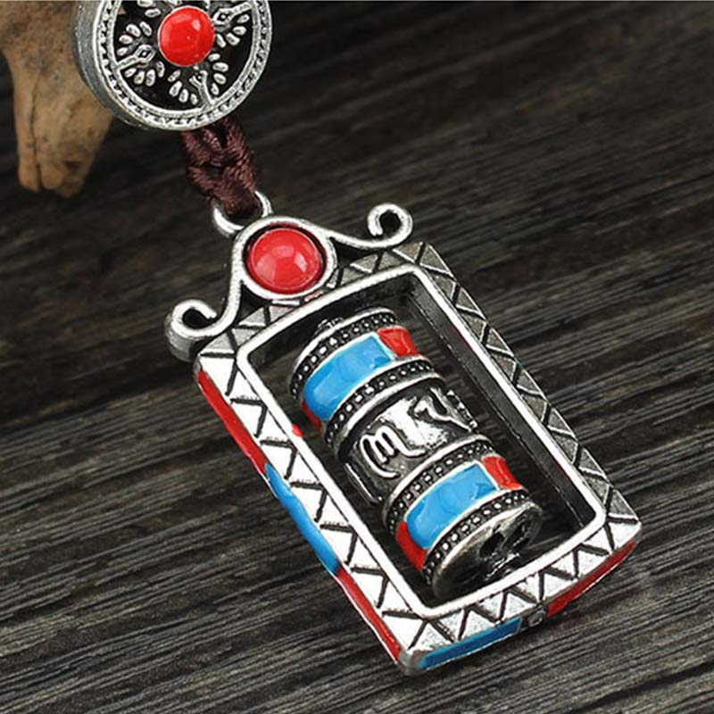 Om Mani Padme Hum Prayer Wheel Keychain – Overhead angle on dark wood grain, close-up of rotating wheel, Tibetan keychain