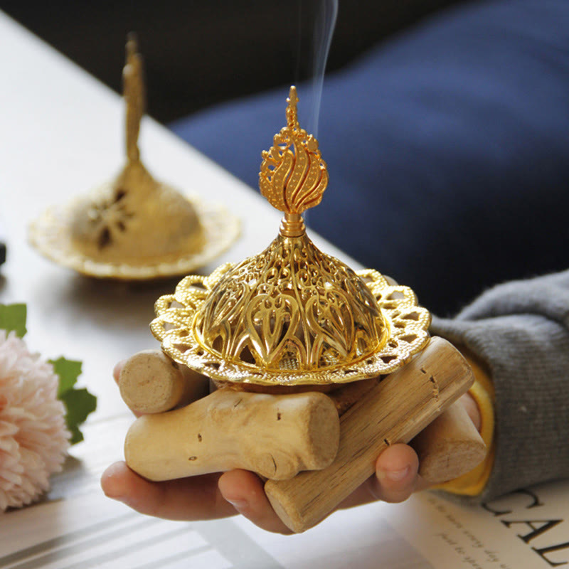 Gold Alloy Mini Incense Burner – hand holding filigree burner with aromatic smoke on driftwood base, luxury home fragrance