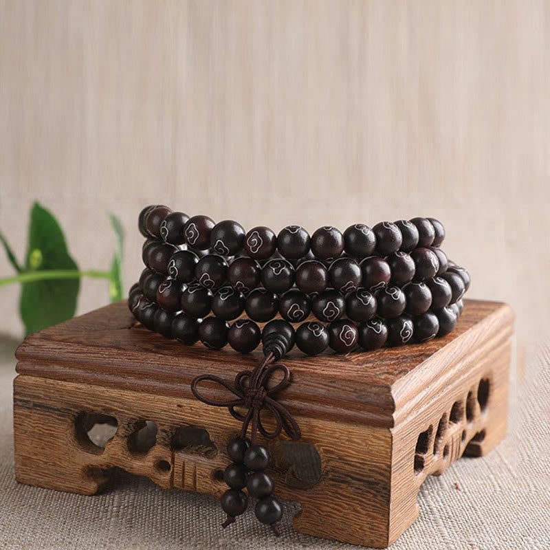 Sterling Silver Sandalwood Mantra Bracelet – full 108 bead mala on wooden display with tassel, meditation beads