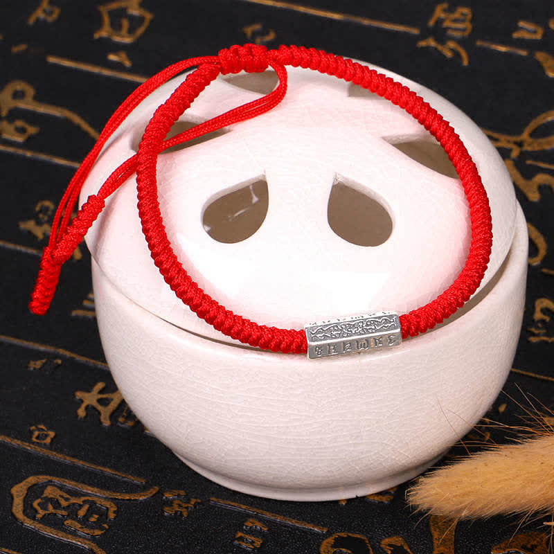Red String Om Mani Padme Hum Bracelet - Red cord on ceramic stand, gold calligraphy background