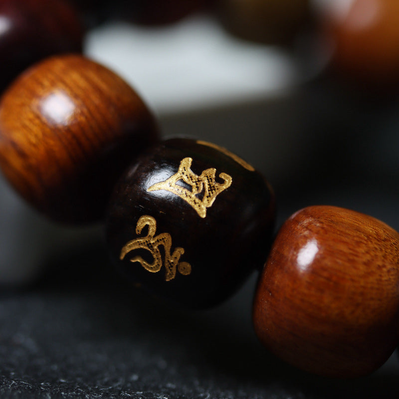 Om Mani Padme Hum Bracelet – gold Om on polished ebony bead beside rosewood, dark slate, mantra jewelry