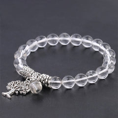 Tree of Life clear quartz bracelet with transparent crystal beads, silver-toned decorative spacers and tree-of-life charm.