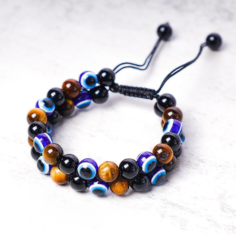Evil Eye Hematite Tiger Eye Bracelet – close-up tiger eye amber and evil eye beads on marble surface