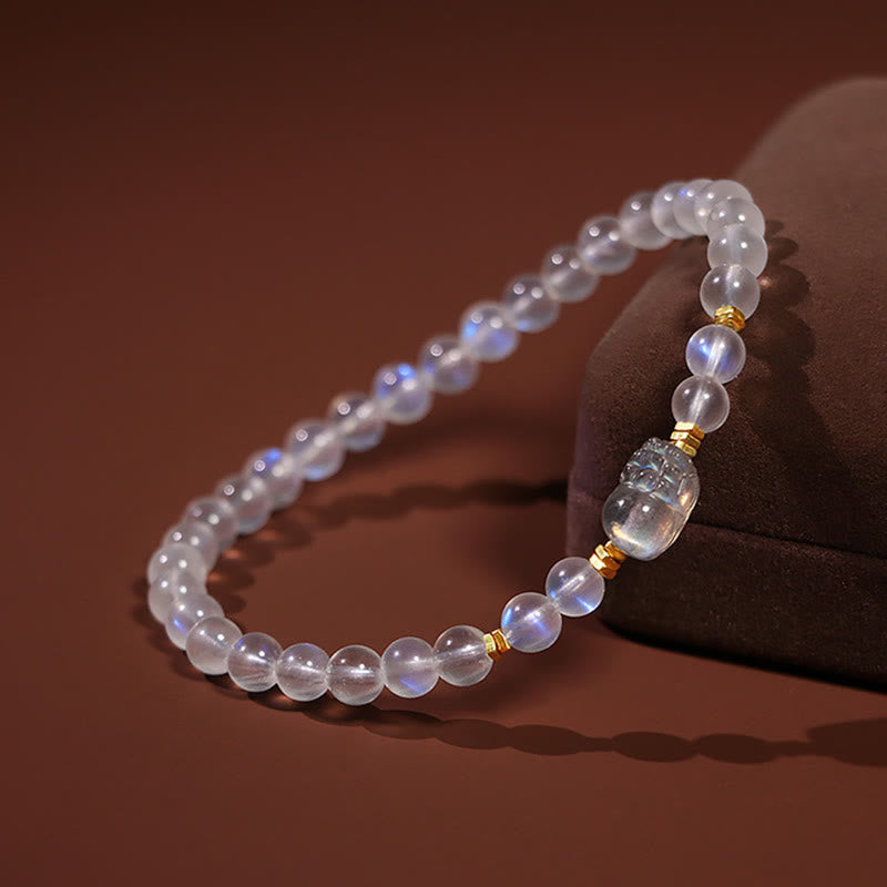 Moonstone PiXiu Bracelet – Bracelet with PiXiu resting on velvet prop side view, wellness jewelry
