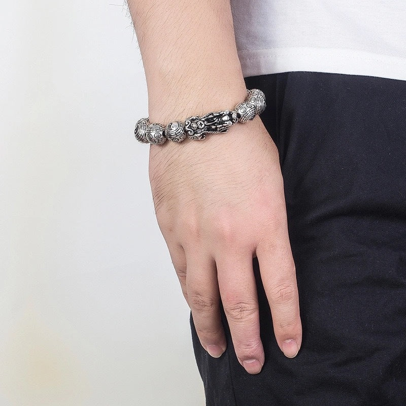 Tibetan Feng Shui PiXiu Silver Bracelet – Worn on male wrist with white sleeve cuff showing everyday wear look with carved Pixiu and Bagua bead details
