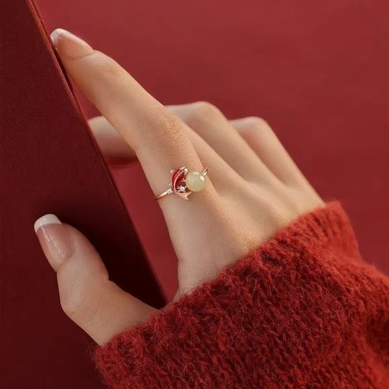 Koi Jade Ring – model hand with red sweater touching red fabric, rose gold koi and jade ring on finger, minimalist design