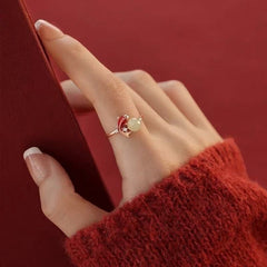 Koi Jade Ring – model hand with red sweater touching red fabric, rose gold koi and jade ring on finger, minimalist design