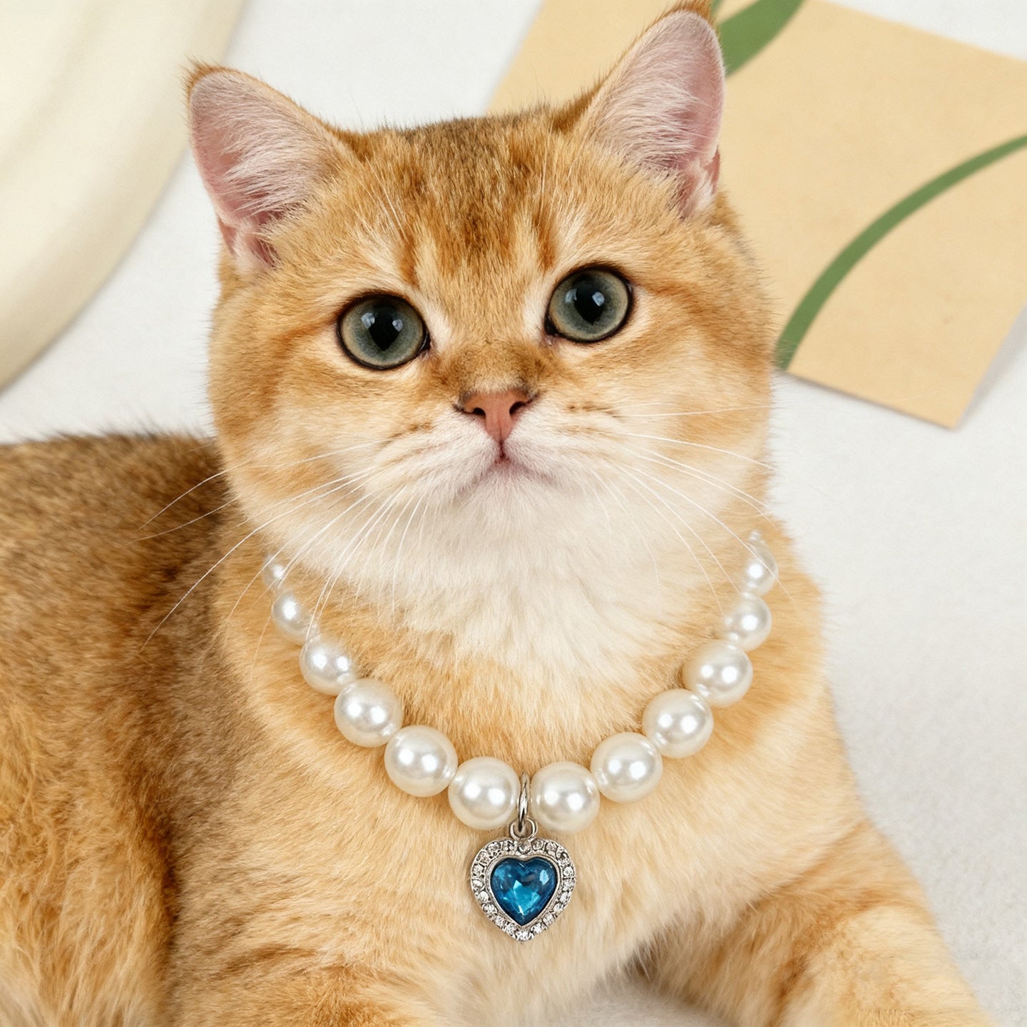 Quartz Heart Pearl Pet Collar – Golden cat wearing pearl blue heart collar, cute pet accessory