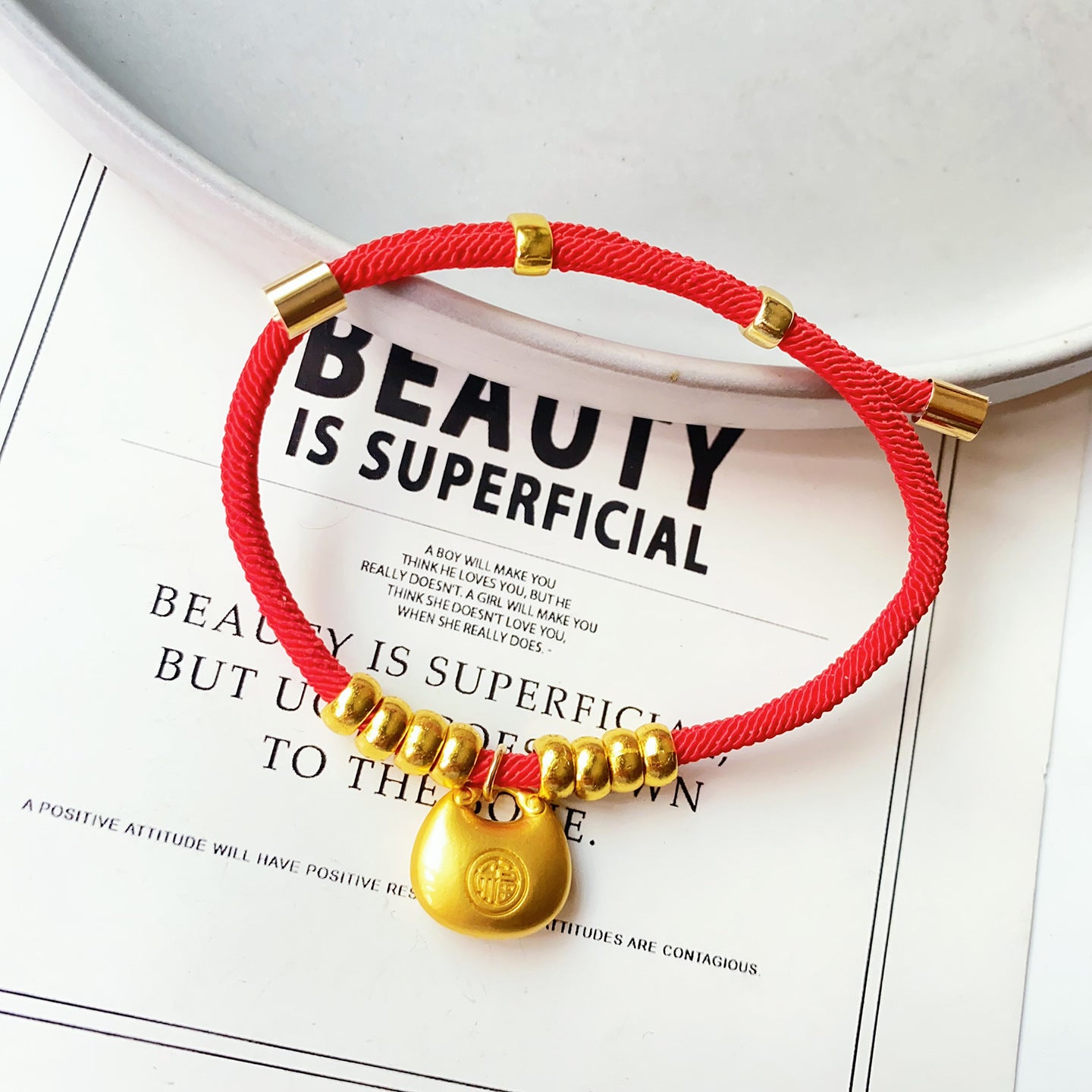 Longevity Lock Pet Collar - Red cord with gold Fu bag pendant on ceramic dish, adjustable gold lucky pet necklace