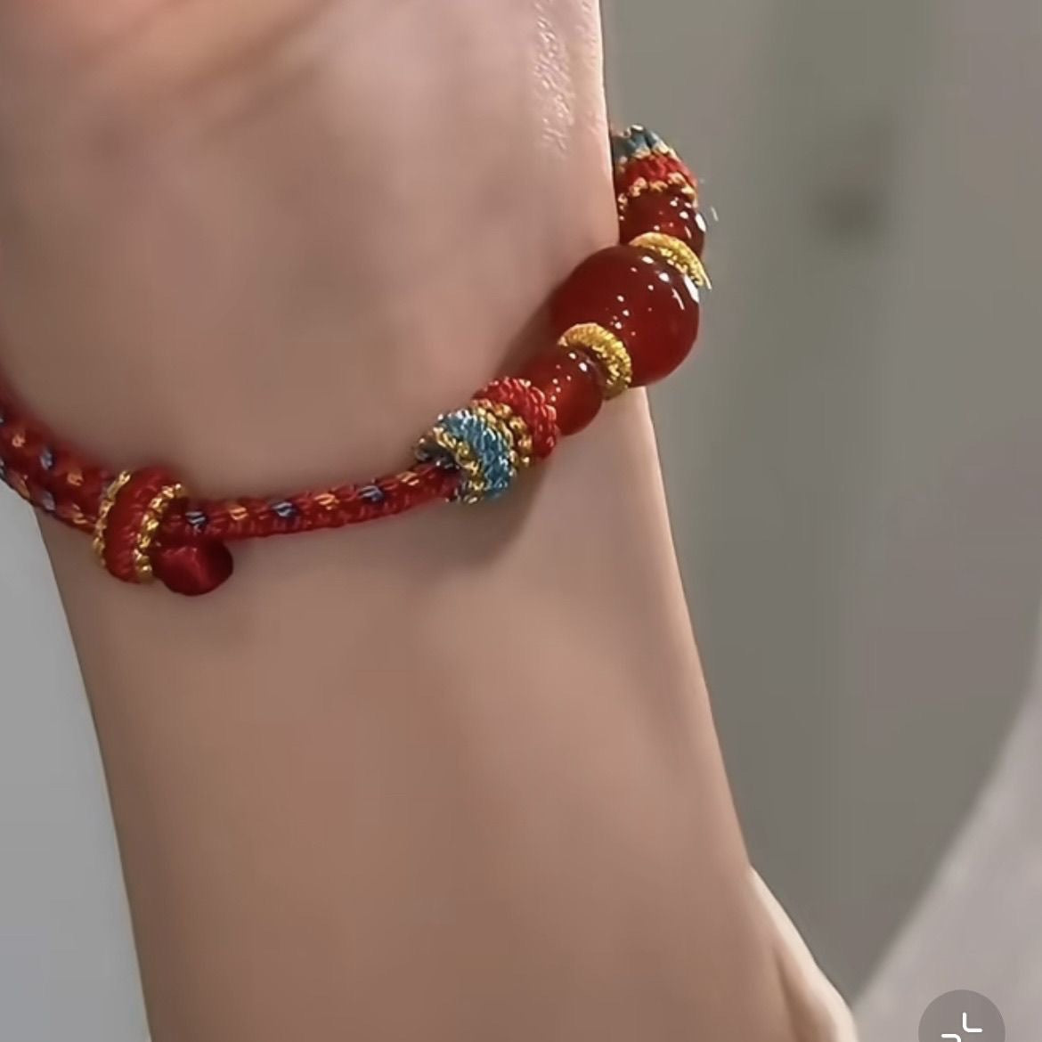 Dunhuang Agate Bracelet – side view of red agate bracelet on wrist showing carnelian shine and woven cord texture, healing stone