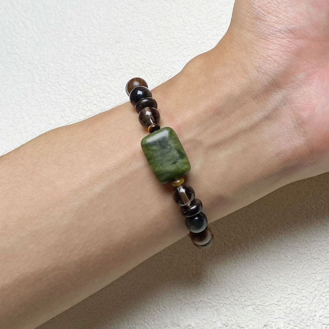 Sandalwood Wushi Bracelet – Bracelet worn on wrist showing green jade plaque and wood grain beads, zen jewelry