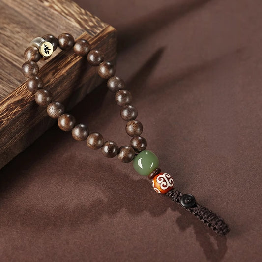 Hetian Jade & Agarwood Zodiac Buddha Keychain – Close-up of agarwood bead texture with green jade, Dzi bead, and engraved gold-tone zodiac symbol