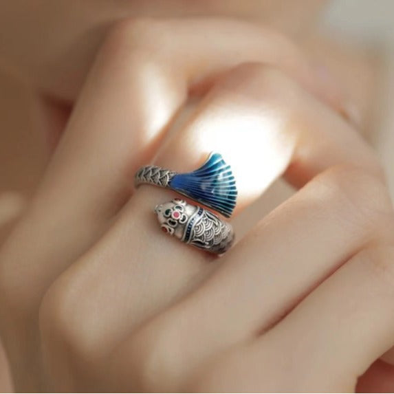 Enamel Carp Ring – two fingers crossed showing blue tail and engraved carp body in warm light, enamel ring