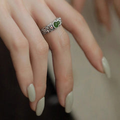 Jade Gourd Ring – side angle of green jade and silver cloud motif ring on finger, dark blurred background, traditional Chinese health ring