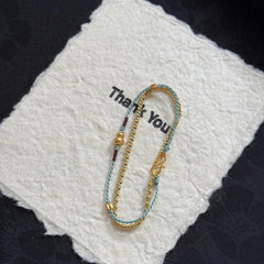 Double-Layer Gourd Bracelet – Detail of gold S-clasp and braided rope with gourd accent on white felt, handmade
