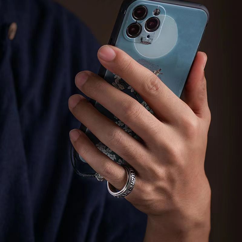 Mantra Phone Ring – person in blue shirt holding phone with ring holder on finger, lifestyle shot