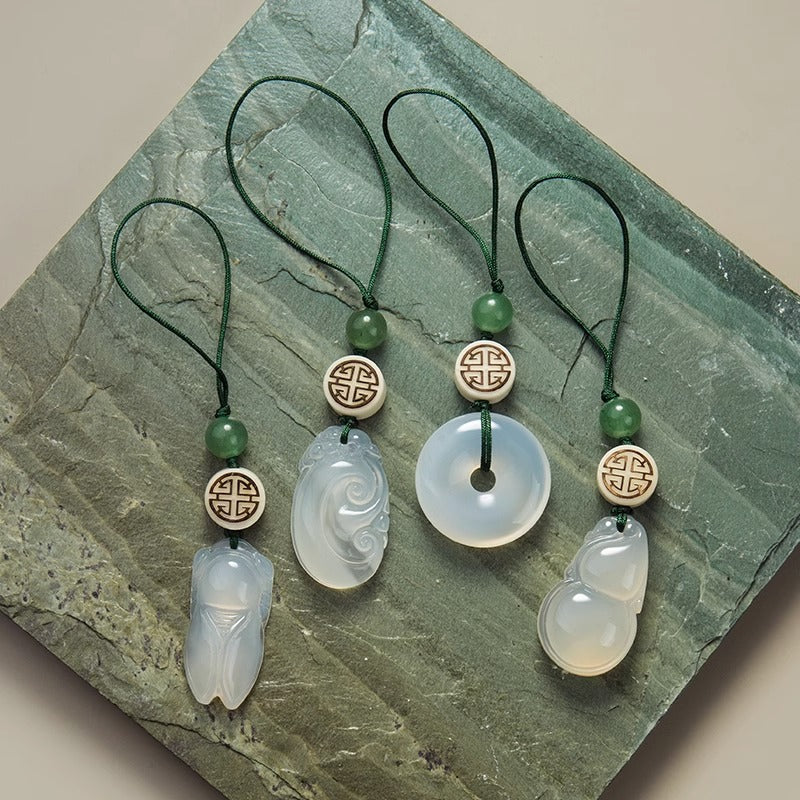 Chalcedony Keychain Set – four pendants arranged on green stone: cicada, ruyi, disc, gourd
