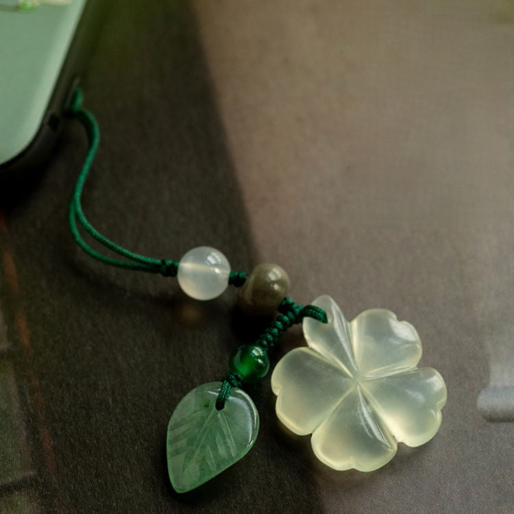 Jade Clover Keychain – close-up of clover and green beads on dark textured surface