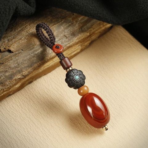 Red Agate Car Keychain – ebony flower turquoise keychain on natural wood slab close-up, handmade amulet