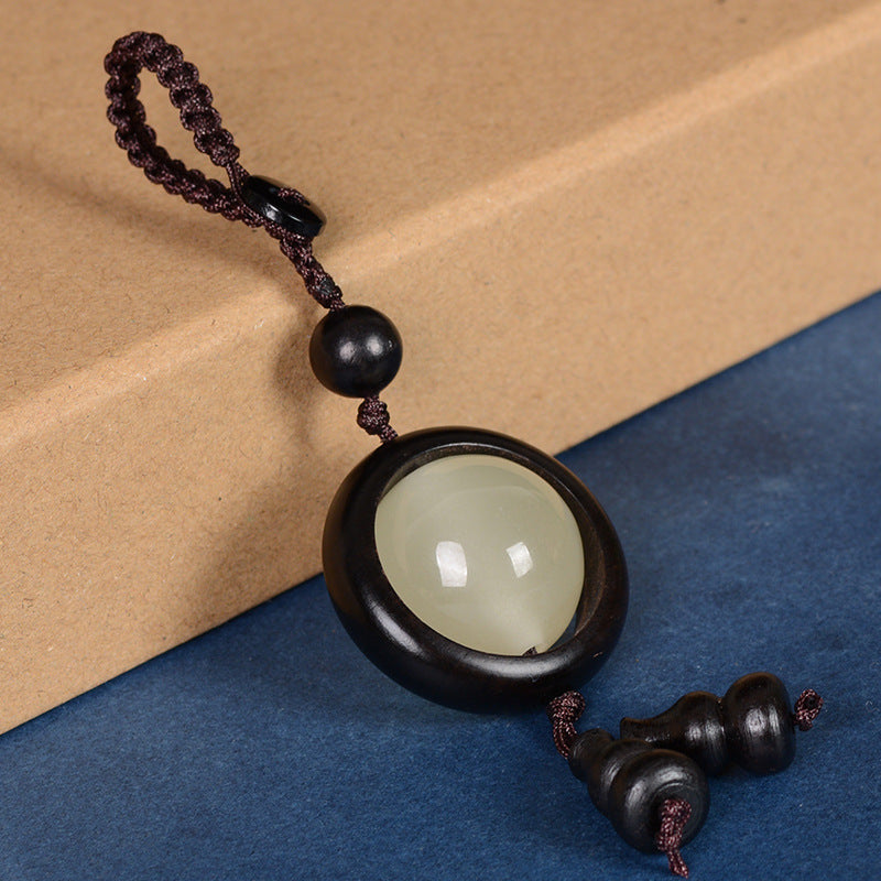 Feng Shui Sandalwood Keychain with Luminous Bead – Bloodwood red version close-up showing wood grain and luminous jade bead