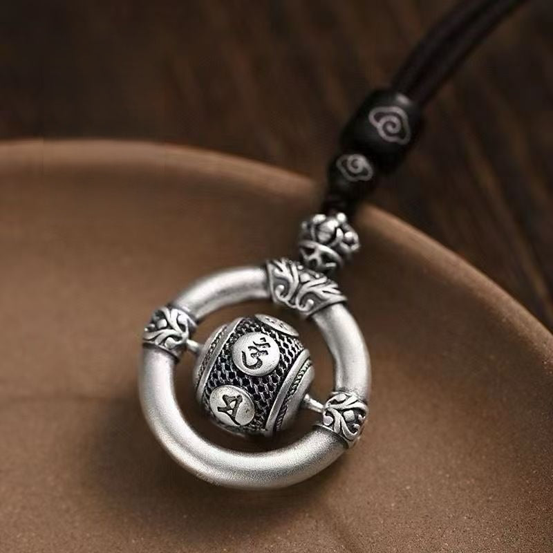 Mantra Keychain – close-up of six sacred mantra engravings on spinning silver bead, detailed craft