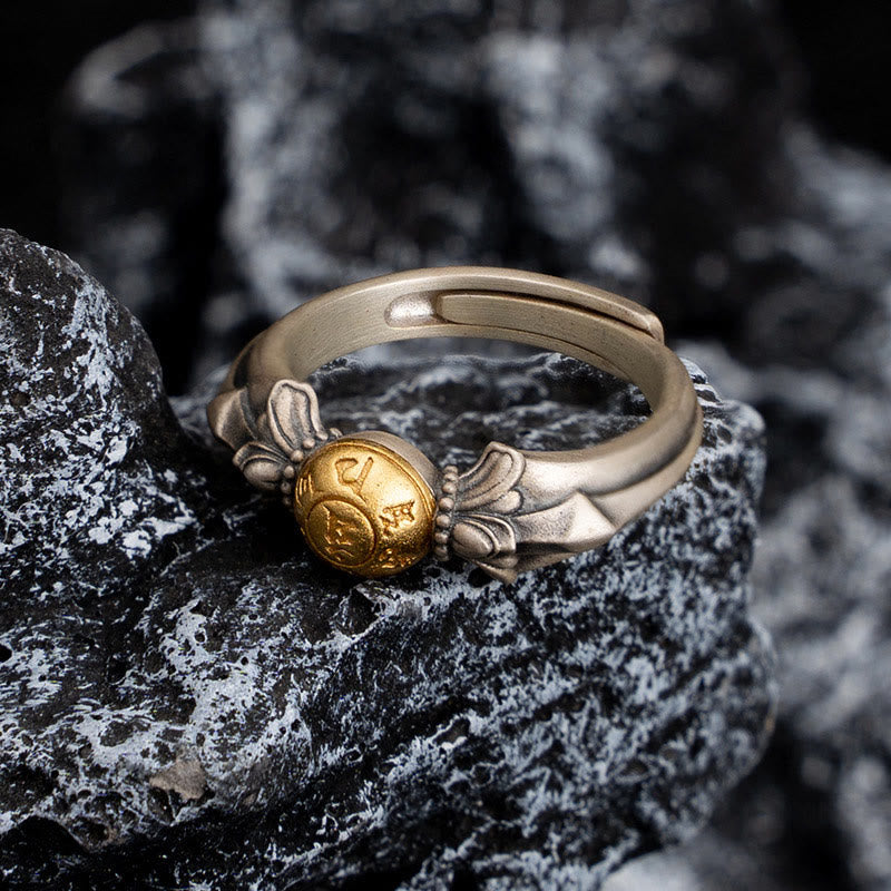 Manjusri Mantra Ring – Gold engraved bead on open silver band resting on volcanic rock, spiritual ring