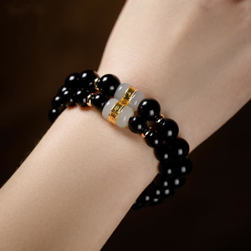 Black Obsidian Jade Bracelet – Multi-strand worn view on dark background showcasing dual jade accent beads