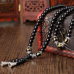 Black Obsidian Mala Bracelet - Draped over embroidered box with gold mantra accent beads, obsidian mala necklace