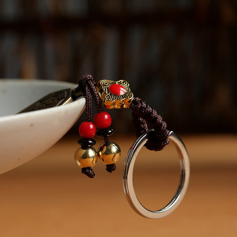 Feng Shui Bagua & Yin Yang Copper Keychain - White background view with brass beads and cord tassels, copper talisman