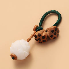 Bodhi Seed Peach Wood Lotus Keychain – Close-up of paired wooden lotus seed pods with carved dark chambers on green lanyard