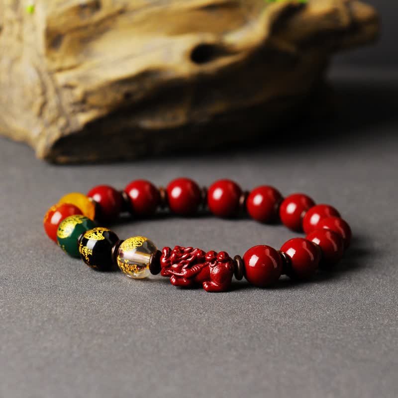 Cinnabar PiXiu Blessing Bracelet – Angled shot with driftwood showing red cinnabar PiXiu and colorful beads
