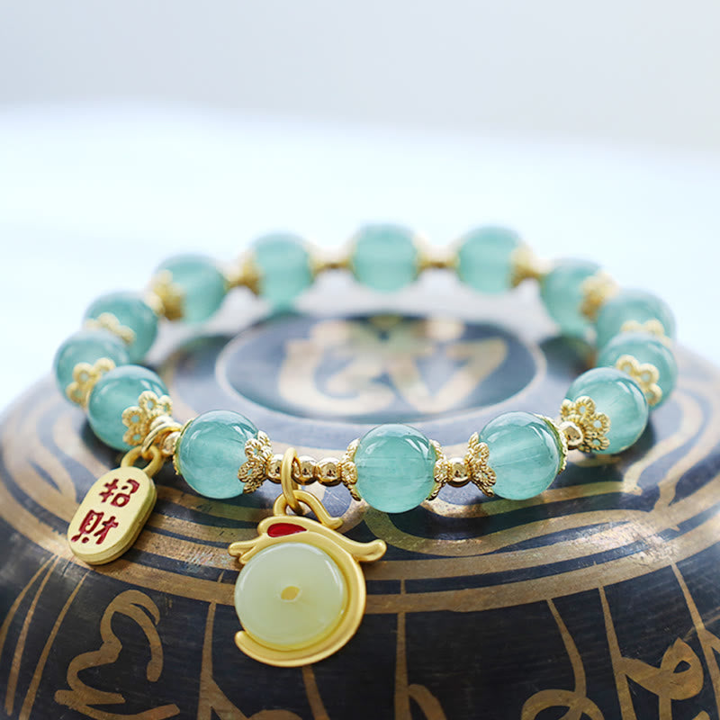 Red Agate Aventurine Dragon Bracelet – Gold wealth charm detail on dark prop, shallow depth, Artisanal
