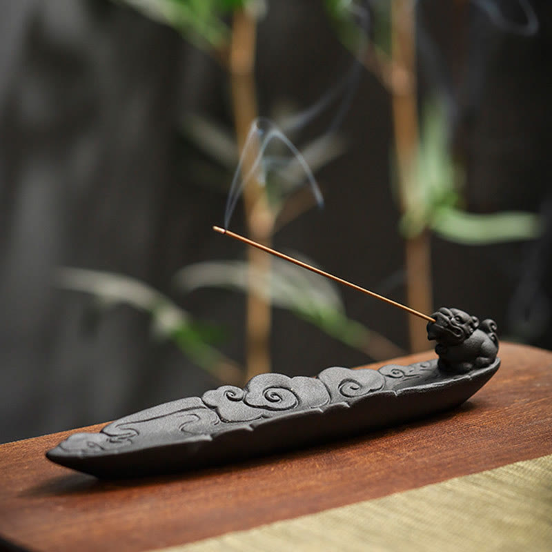 Pixiu incense burner with smoke rising against dark bamboo bokeh, ruyi cloud relief, warm wood surface – Chinese ceramic incense holder