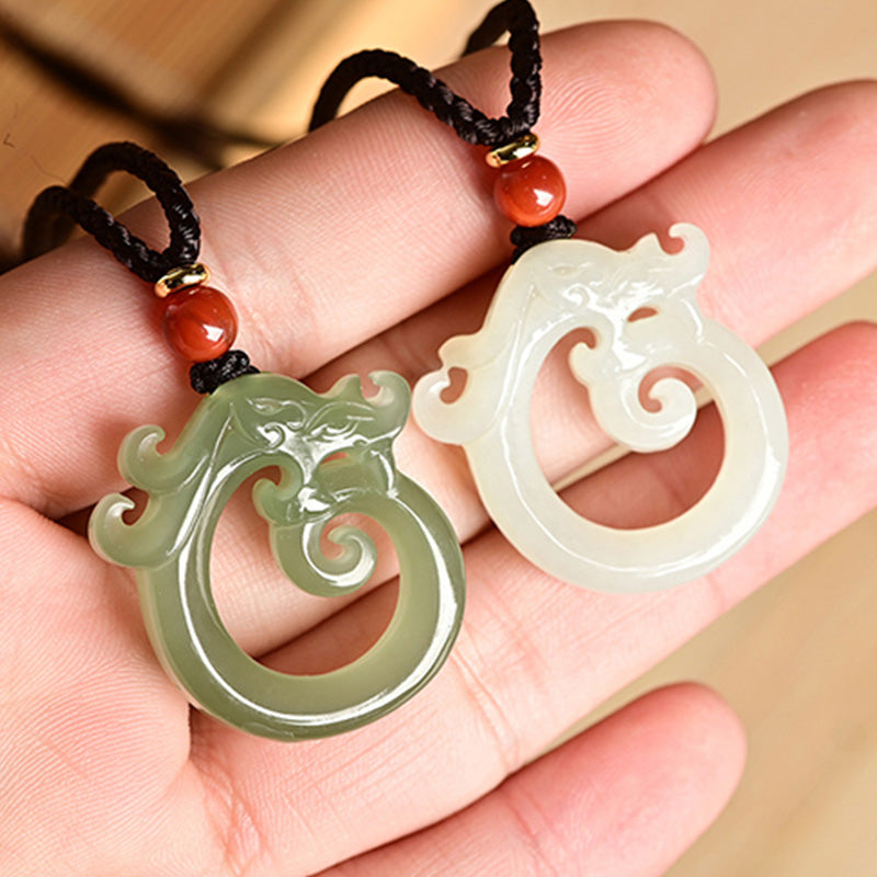 White Jade Cyan Jade Dragon Pendant – green and white jade pair held in palm, meaningful