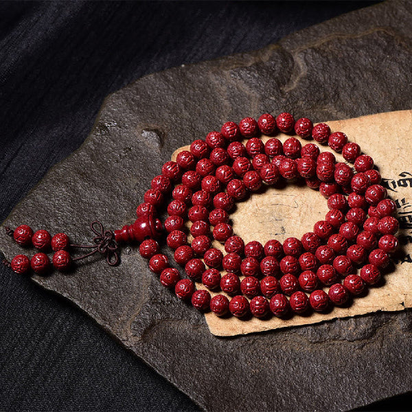 108 Mala Beads Cinnabar Bracelet – Elevated view on stone slab, cinnabar mala
