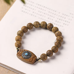 Green Sandalwood & Ebony Soothing Bracelet – lifestyle flat lay with botanical accent, carved wood mala beads and blue sto...