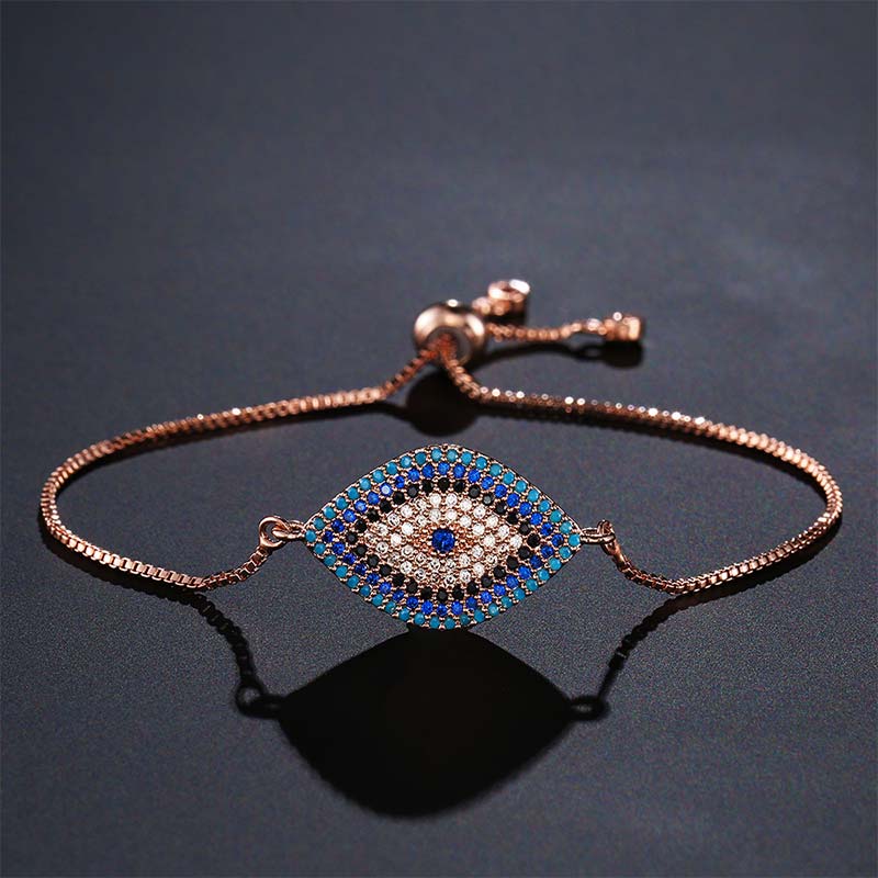 Evil Eye Healing Bracelet – Rose gold nazar bracelet with blue pave evil eye on dark charcoal surface