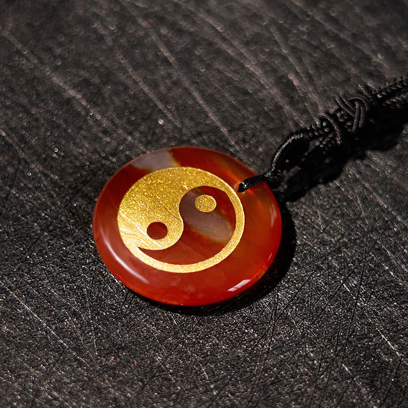 Yin Yang Crystal Necklace – Amber stone round pendant with gold yin-yang inlay, glossy polished warm orange stone on black co